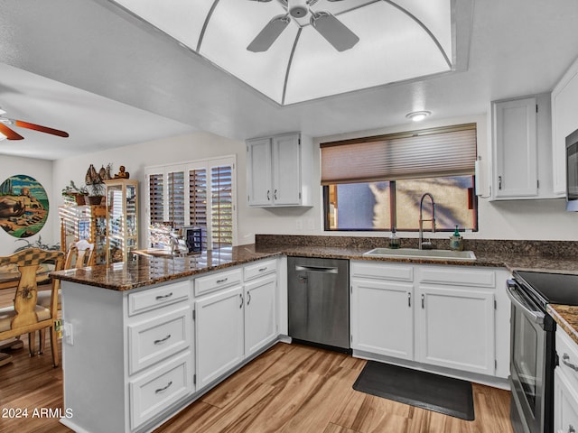 kitchen featuring dishwasher, kitchen peninsula, and white cabinets