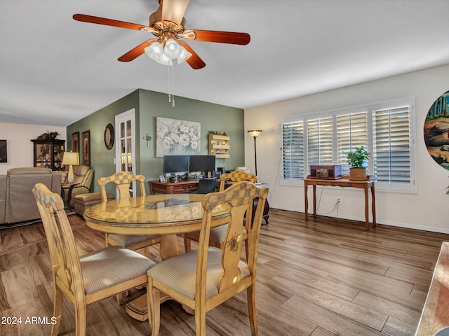 dining area featuring light wood-type flooring, ceiling fan, and vaulted ceiling