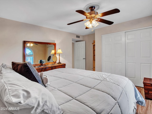 bedroom with hardwood / wood-style flooring, ceiling fan, and a closet