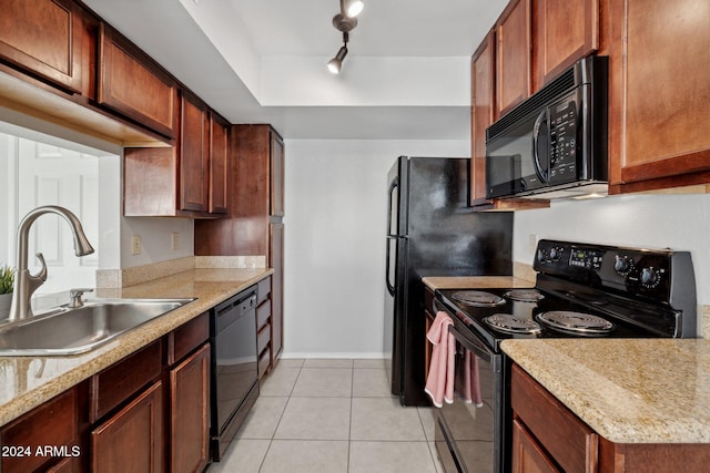 kitchen featuring light stone countertops, rail lighting, sink, black appliances, and light tile patterned floors