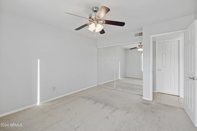 unfurnished bedroom with ceiling fan, a closet, and light colored carpet