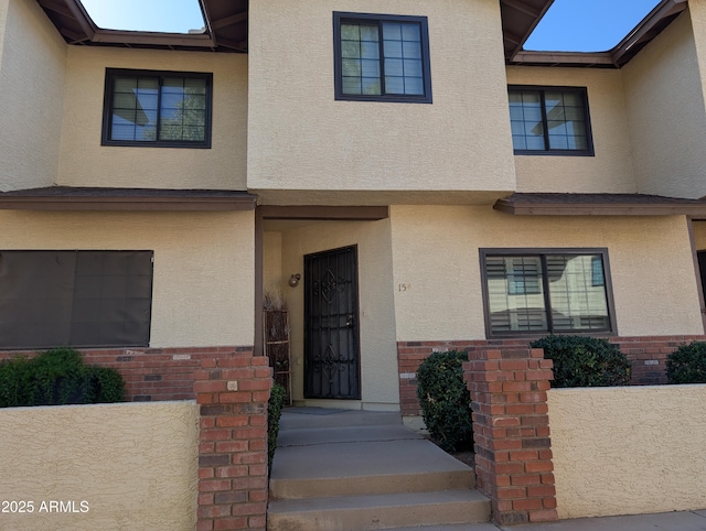 view of front of home with stucco siding and brick siding