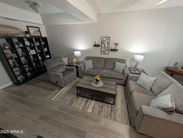 living area with a textured ceiling and wood finished floors