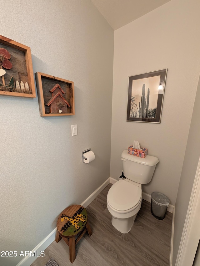 bathroom with toilet, wood finished floors, and baseboards