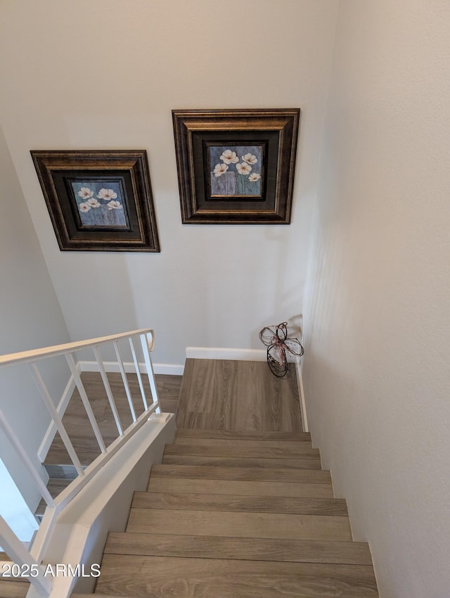 staircase with wood finished floors and baseboards