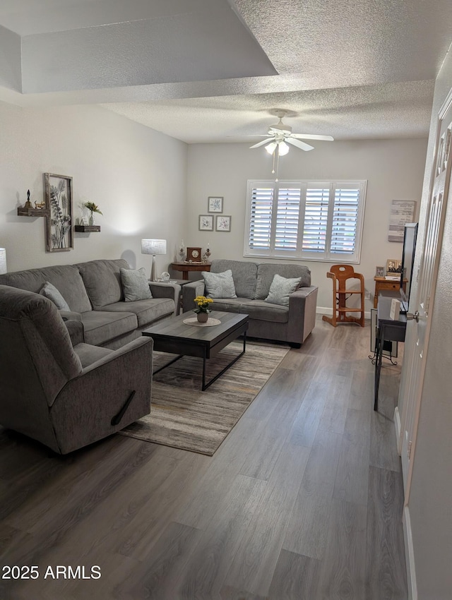 living room featuring a textured ceiling, a ceiling fan, and wood finished floors