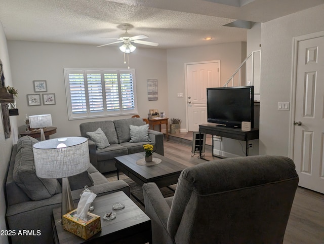 living area featuring a textured ceiling, wood finished floors, and ceiling fan