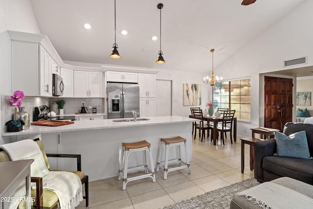 kitchen featuring visible vents, light tile patterned flooring, white cabinets, appliances with stainless steel finishes, and open floor plan