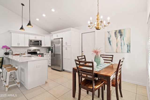 kitchen featuring a sink, stainless steel appliances, a peninsula, and light tile patterned flooring