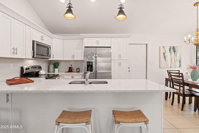 kitchen with light tile patterned floors, a sink, white cabinets, appliances with stainless steel finishes, and backsplash