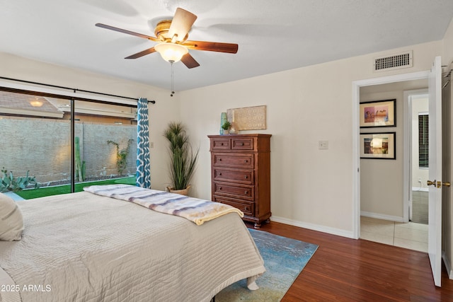 bedroom featuring wood finished floors, visible vents, baseboards, ceiling fan, and access to outside