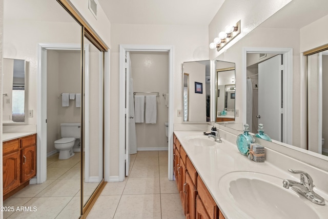 bathroom featuring tile patterned floors, toilet, and a sink