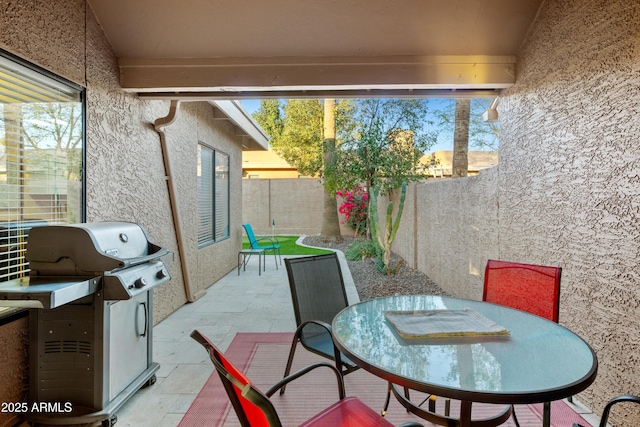 view of patio featuring outdoor dining area, area for grilling, and a fenced backyard