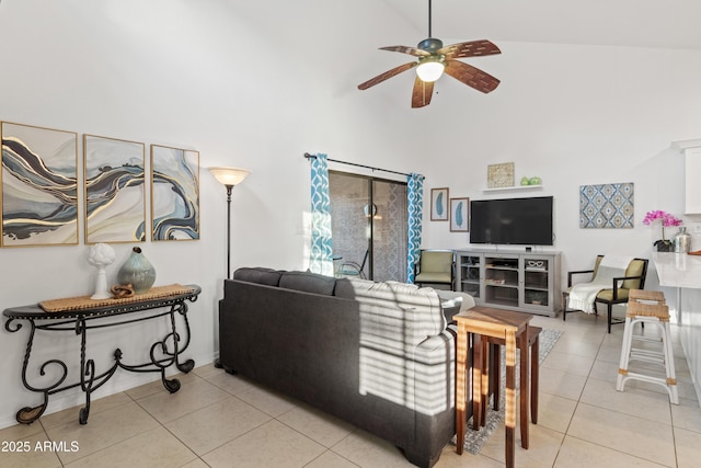 living area featuring light tile patterned floors, a ceiling fan, and high vaulted ceiling