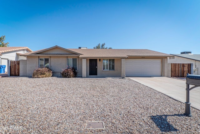 single story home with concrete driveway, fence, and an attached garage