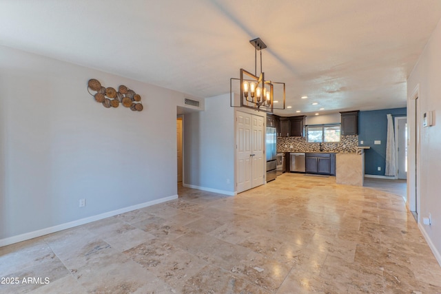 kitchen featuring hanging light fixtures, baseboards, visible vents, and backsplash