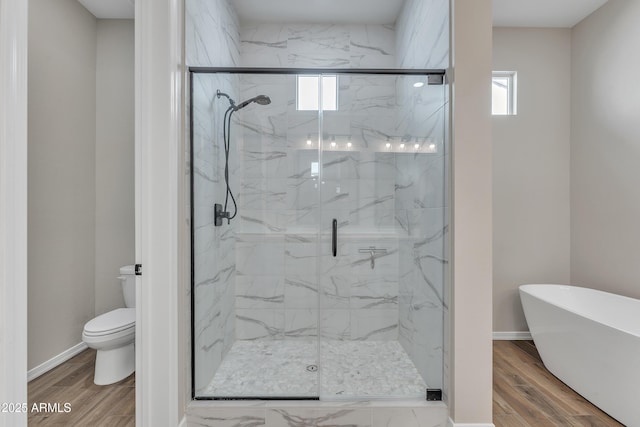 bathroom with a marble finish shower, wood finished floors, toilet, and baseboards