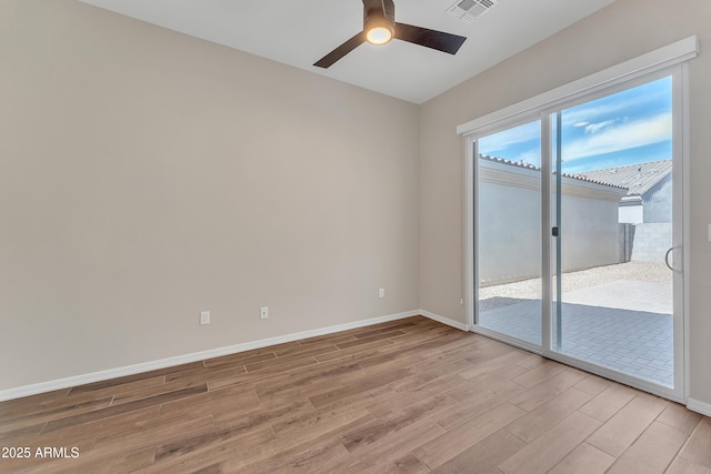 empty room featuring light wood-type flooring, visible vents, ceiling fan, and baseboards