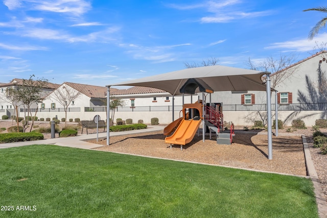 community play area featuring a yard and fence