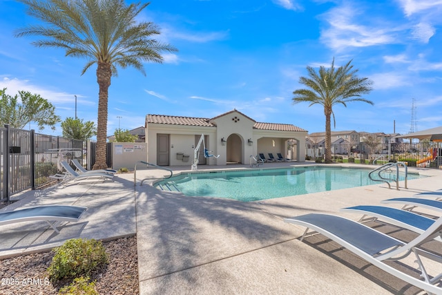 community pool featuring a patio and fence