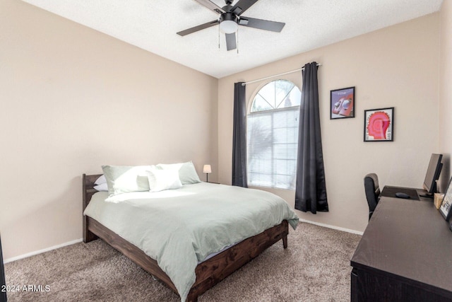 carpeted bedroom with ceiling fan and a textured ceiling