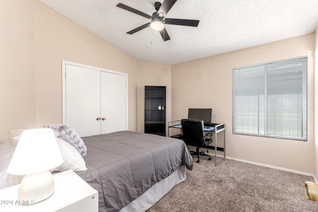 bedroom featuring vaulted ceiling, carpet flooring, ceiling fan, a textured ceiling, and a closet