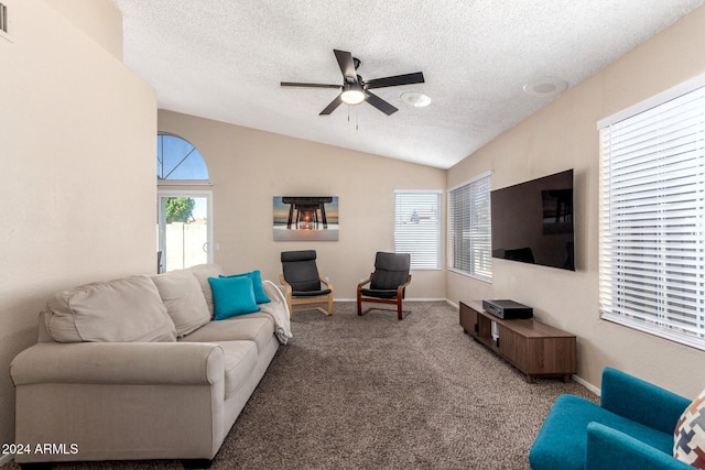 living room with a textured ceiling, ceiling fan, carpet flooring, and vaulted ceiling