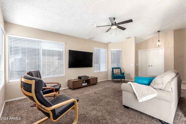 carpeted living room featuring a textured ceiling, ceiling fan, and vaulted ceiling