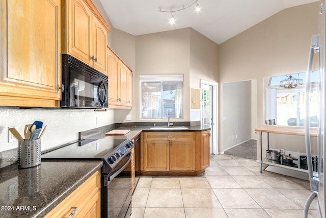 kitchen featuring sink, dark stone counters, a chandelier, light tile patterned floors, and black appliances