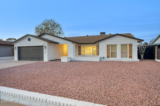 single story home with concrete driveway, brick siding, an attached garage, and a shingled roof