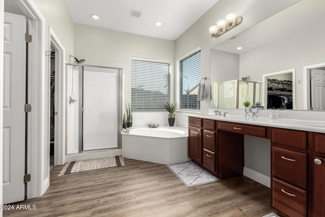 bathroom featuring vanity, plus walk in shower, and wood-type flooring