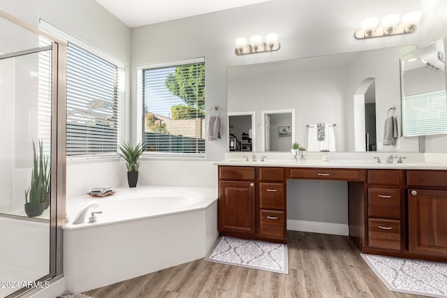 bathroom with hardwood / wood-style flooring, vanity, and independent shower and bath