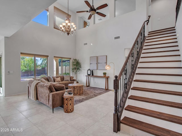 tiled living room with ceiling fan with notable chandelier