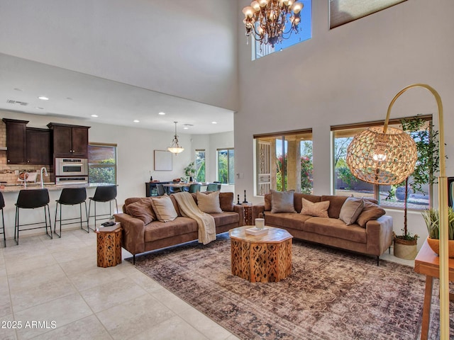 living room with sink, a wealth of natural light, a chandelier, and light tile patterned floors