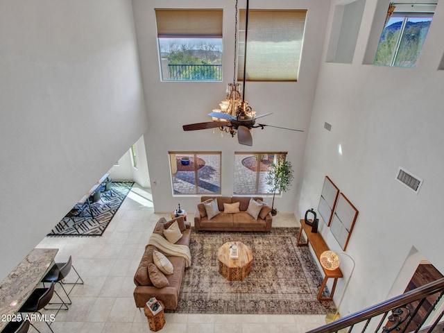 living room with ceiling fan and a high ceiling