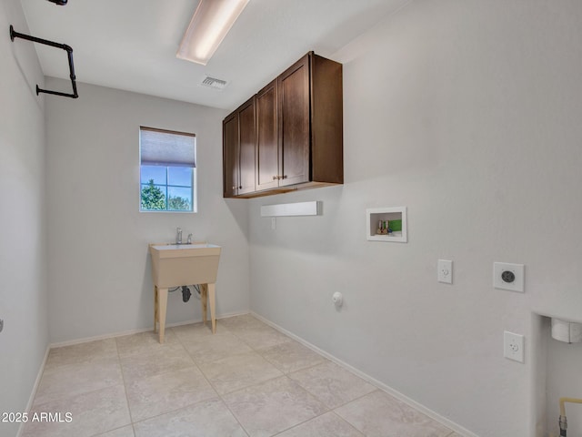 laundry area featuring gas dryer hookup, light tile patterned flooring, cabinets, washer hookup, and electric dryer hookup