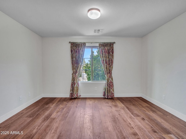 unfurnished room with wood-type flooring