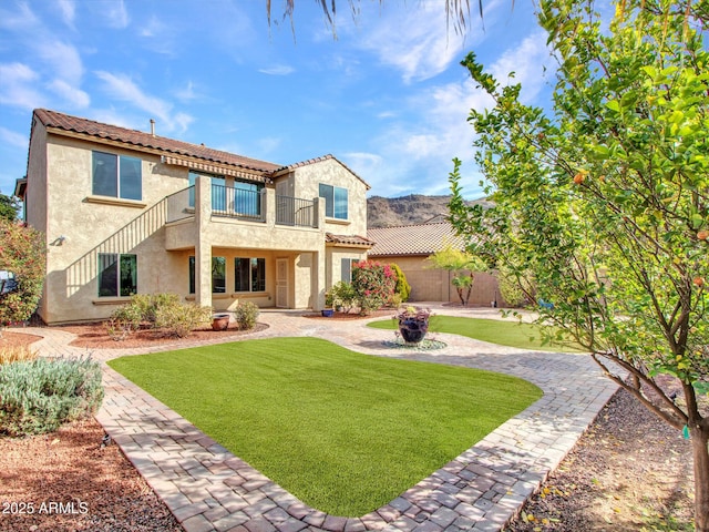 mediterranean / spanish-style house with a balcony and a front yard