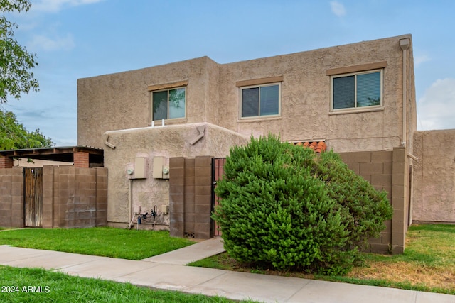 pueblo-style home featuring a front yard