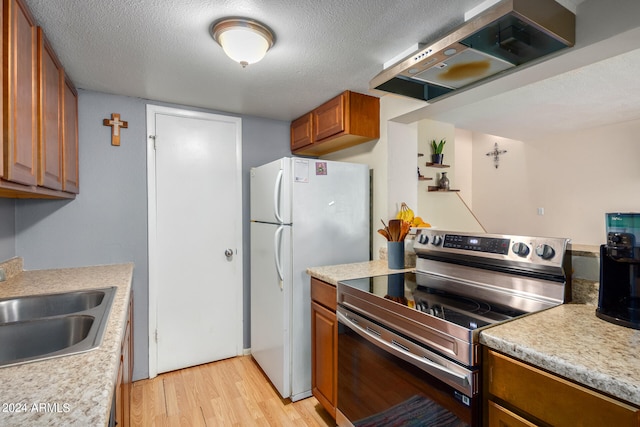 kitchen with light wood-type flooring, sink, island range hood, stainless steel range with electric cooktop, and a textured ceiling