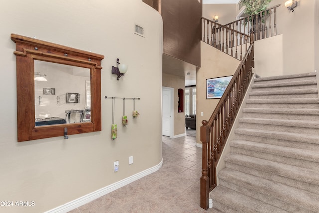 interior space featuring a towering ceiling and tile patterned flooring