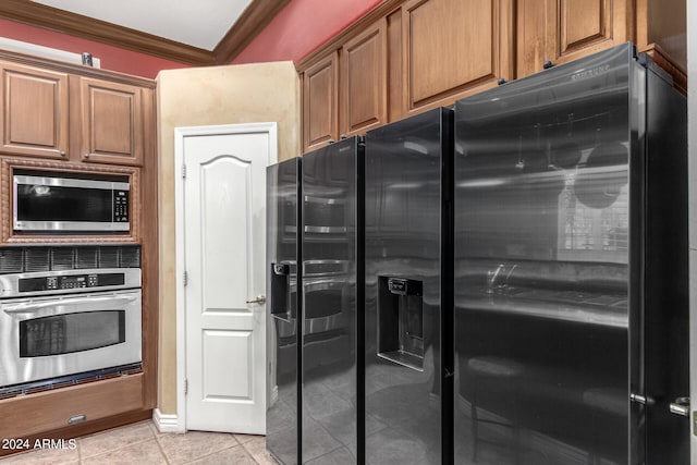 kitchen with stainless steel appliances, light tile patterned floors, and crown molding