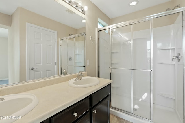 bathroom with vanity and a shower with door