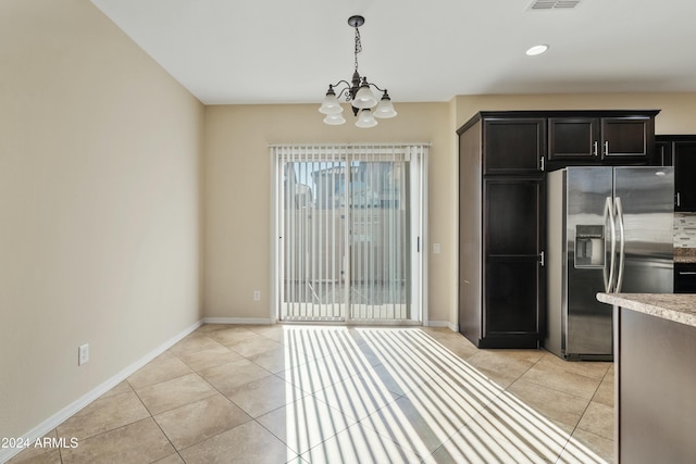 kitchen featuring light tile patterned floors, pendant lighting, stainless steel refrigerator with ice dispenser, and a notable chandelier