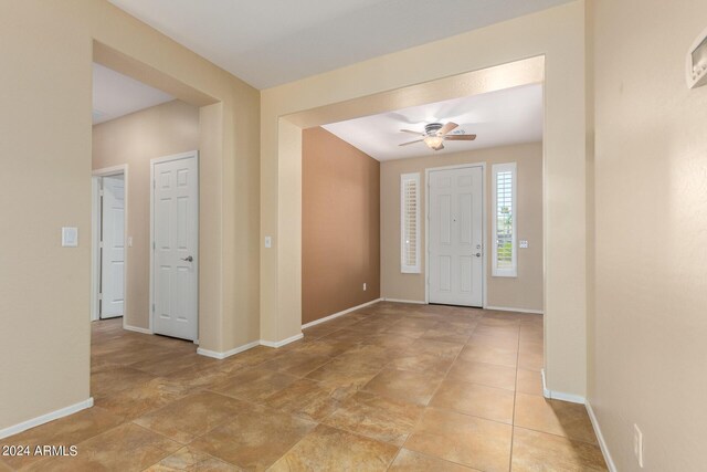 entryway featuring baseboards and a ceiling fan