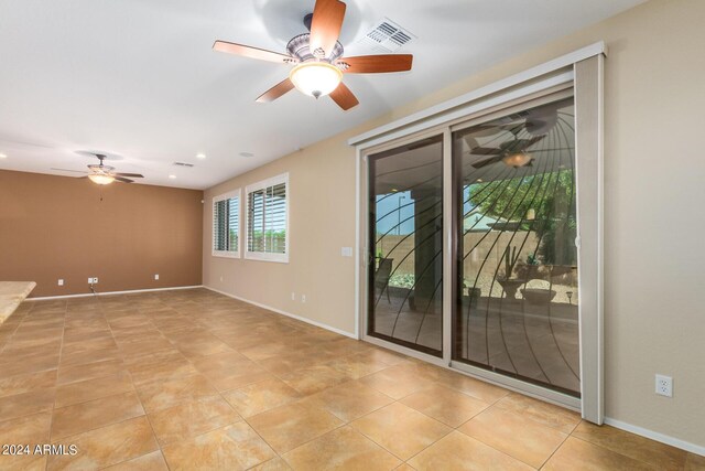 spare room featuring a ceiling fan, light tile patterned flooring, baseboards, and visible vents