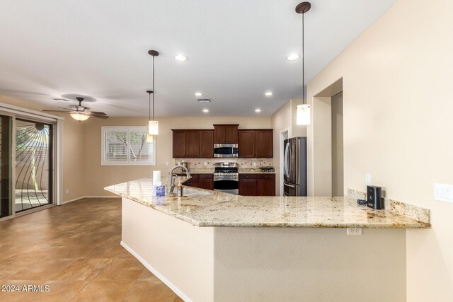 kitchen featuring light stone counters, a sink, stainless steel appliances, decorative backsplash, and recessed lighting