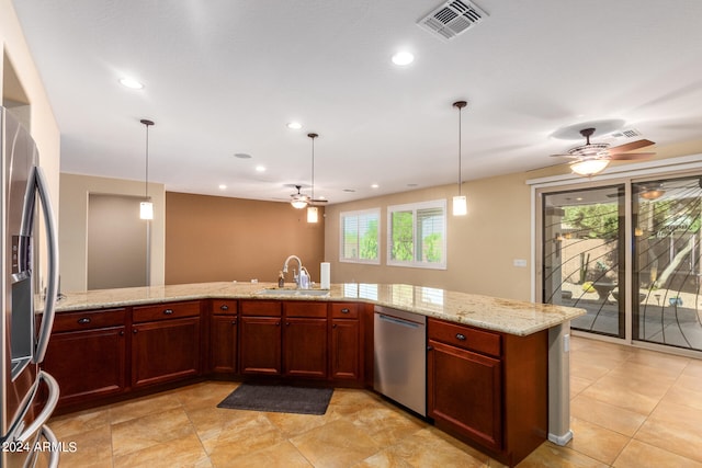 kitchen featuring appliances with stainless steel finishes, light stone countertops, decorative light fixtures, and sink