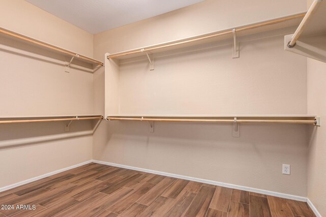 walk in closet with wood finished floors