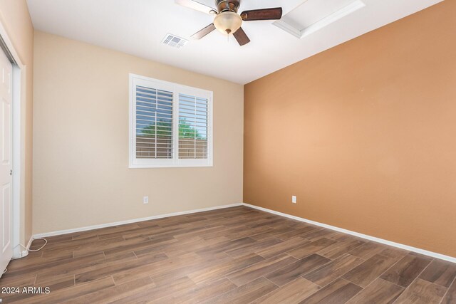 unfurnished room with baseboards, ceiling fan, visible vents, and wood finished floors